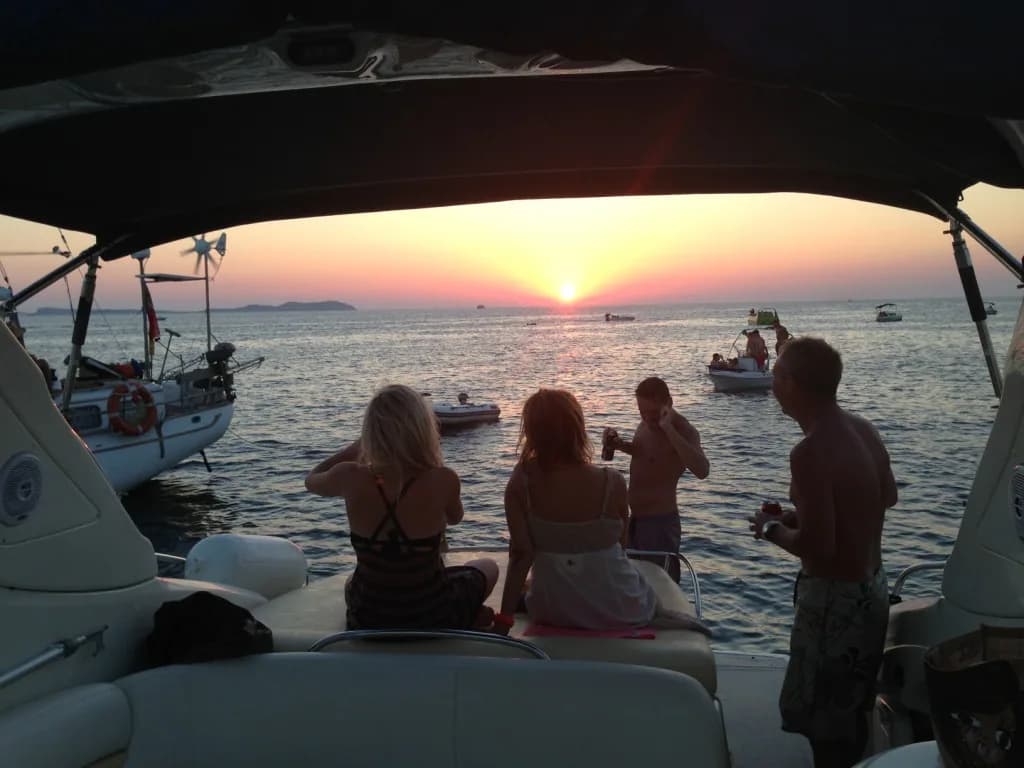 A group watching the sunset from the deck of a charter boat off Ibiza